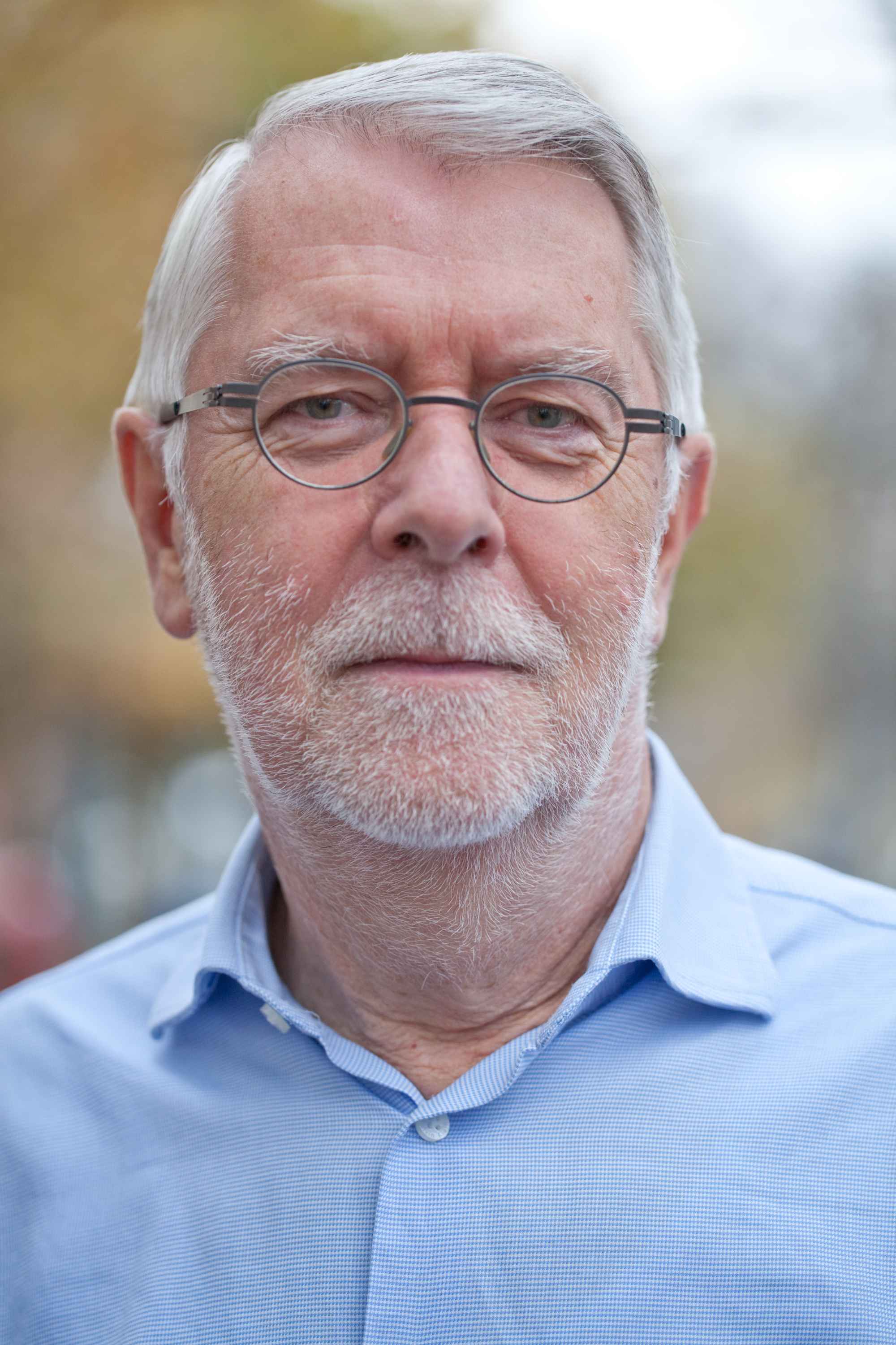 Porträt eines älteren Mannes mit grauem Haar, Brille, Naturhintergrund – Mitarbeiterfoto.
