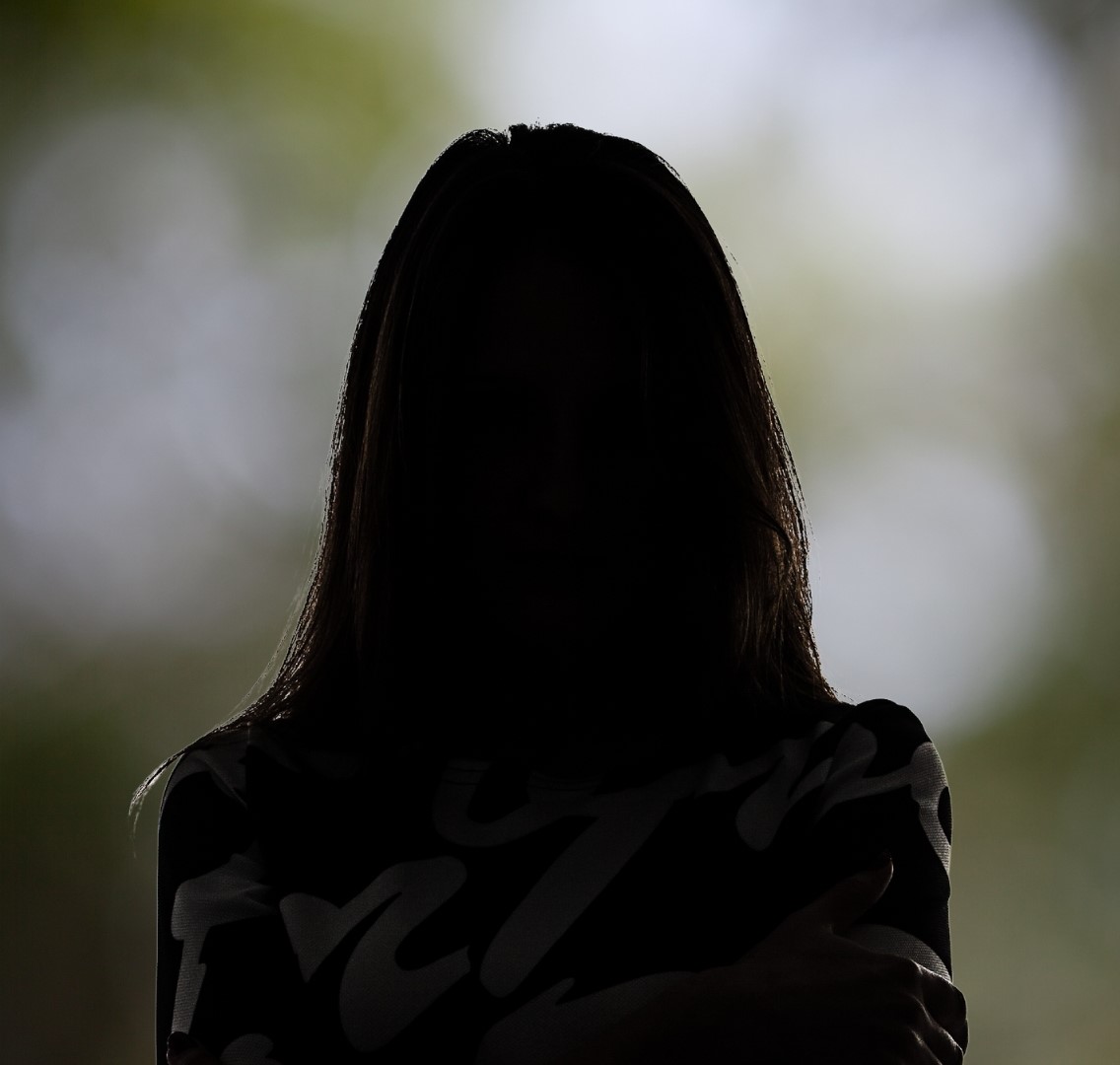 Silhouette einer Frau mit langen Haaren im Freien – Porträt mit Naturhintergrund.