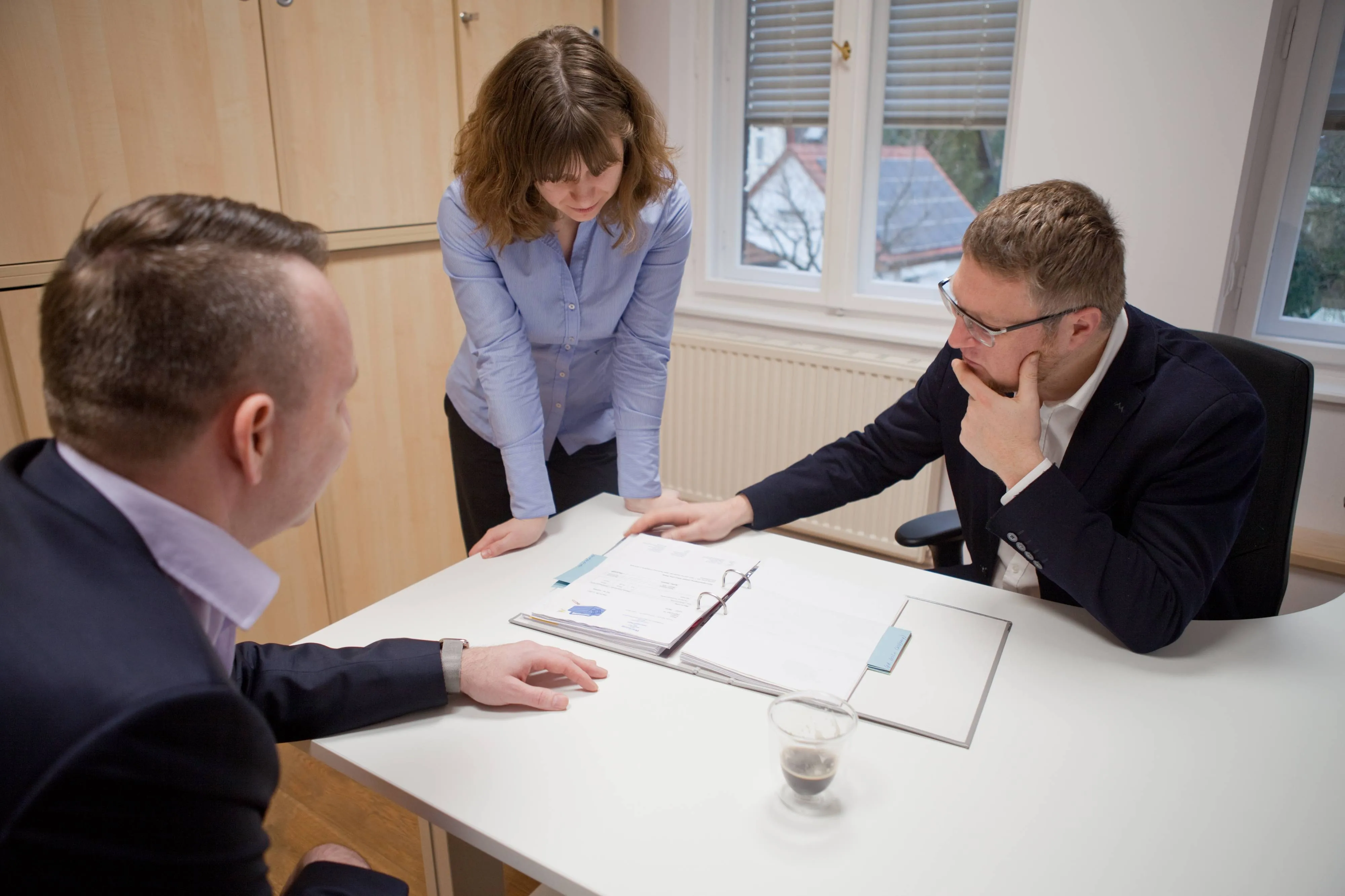 Zwei Männer und eine Frau bei Vertragsbesprechung am Tisch – Meeting.