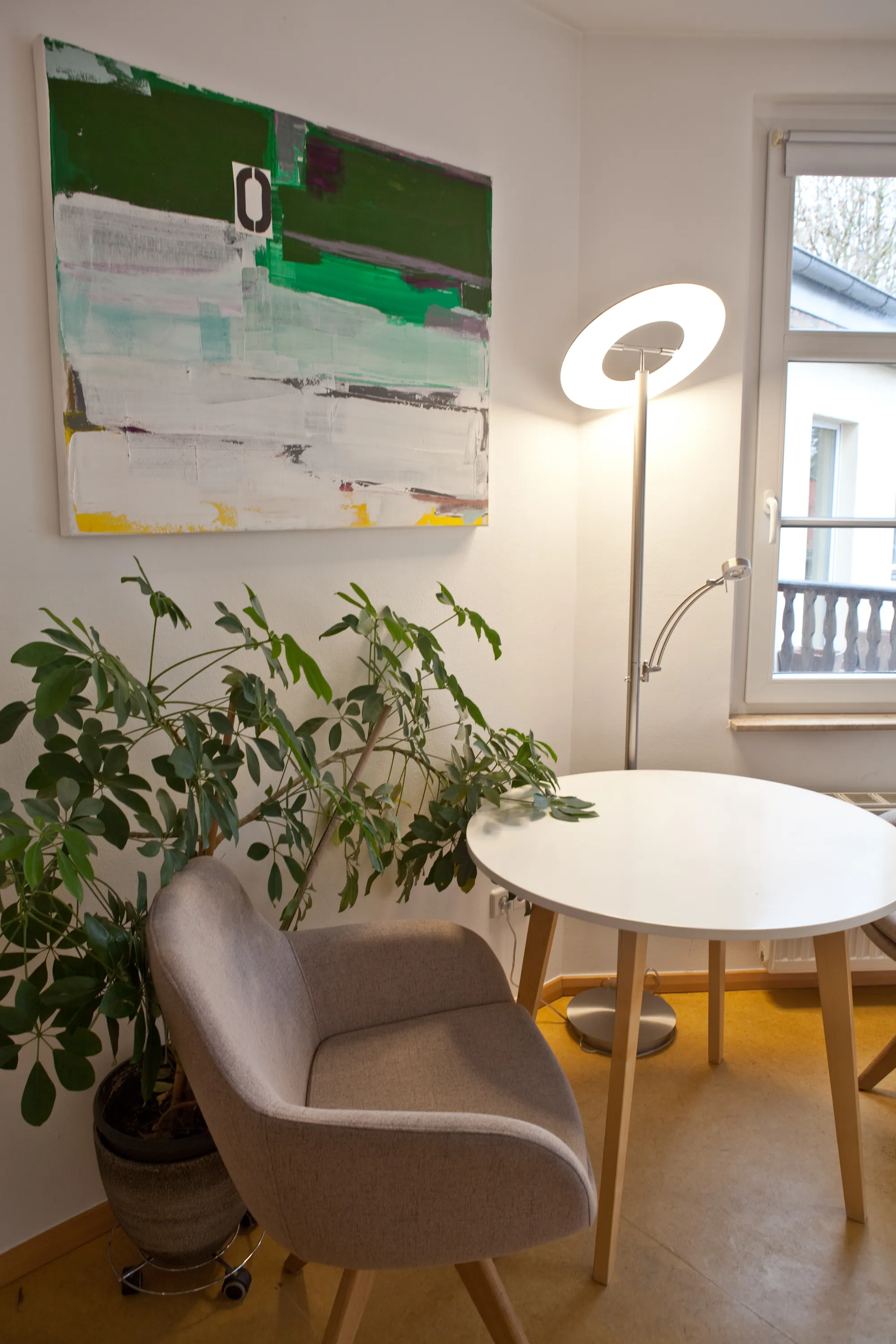 Heller Büroraum mit Schreibtisch, Pflanzen und Sessel – moderner Arbeitsplatz.